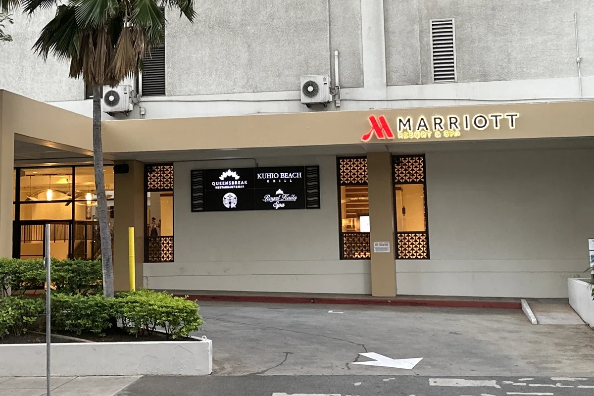 Wejście na poziomie ulicy do Waikiki Beach Marriott Resort & Spa przy Kalākaua Avenue, palmy po obu stronach